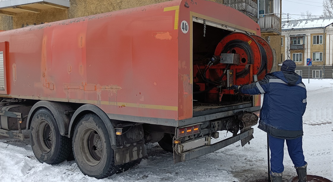 Каналопромывочная машина и работник прочищают засор в канализационной системе в Белогорске